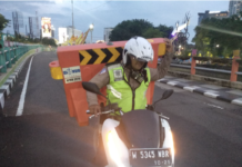 Pakar SEO Indonesia Abadikan Aksi Polantas Surabaya Dalam Gerimis Pindahkan Road Barrier